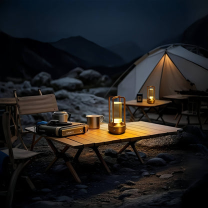 Portable lantern lamps illuminating a table and tent in a campsite scene