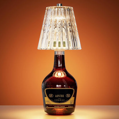 Clear patterned bottle-top lamp glowing on a dark glass bottle