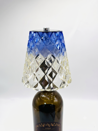 Blue diamond-pattern bottle-top lamp fitted to a dark glass bottle